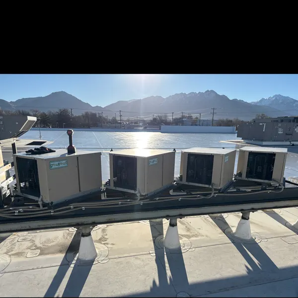 Row of four rooftop HVAC units with the Wasatch Front in the background